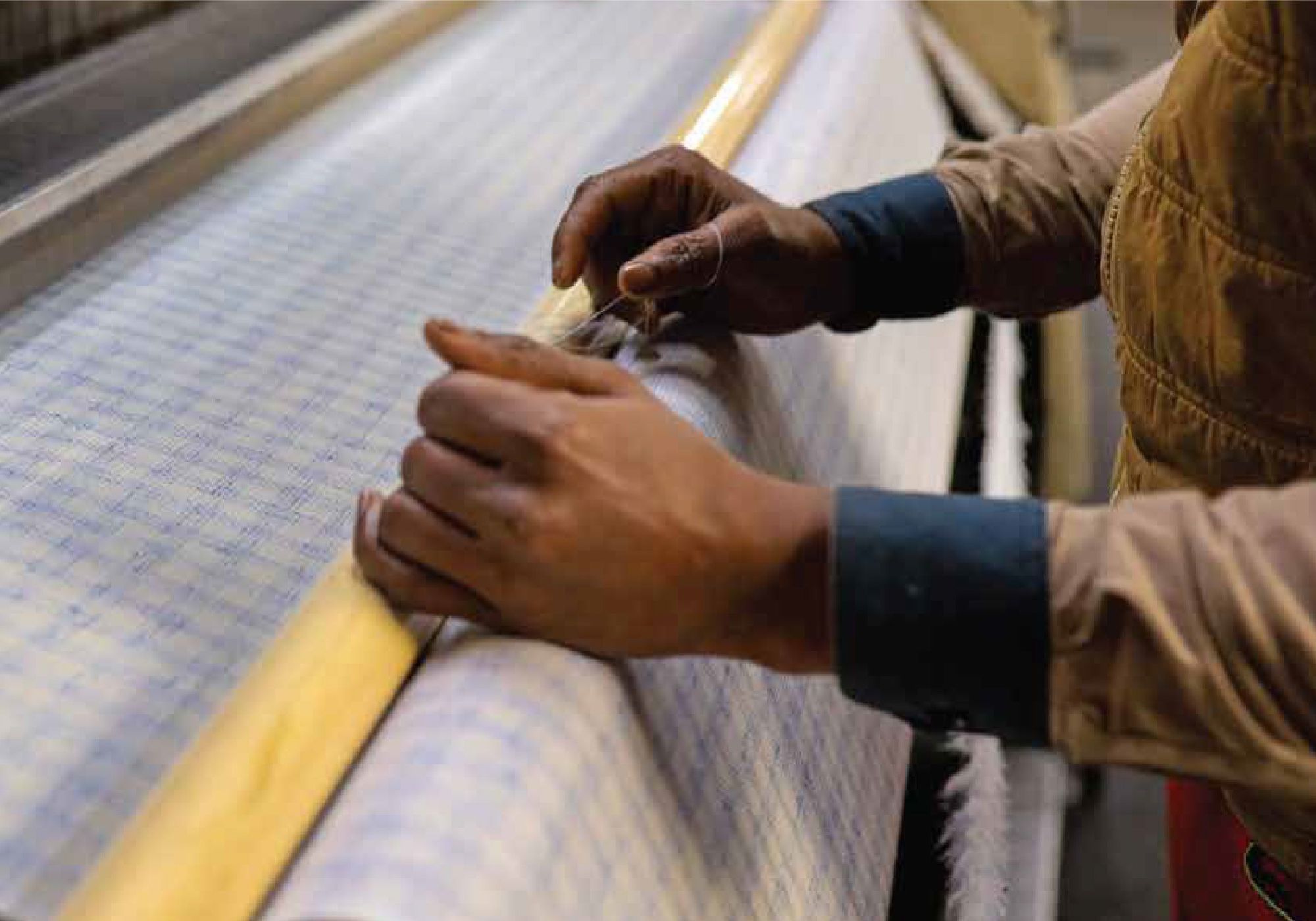 Weaver checking fabric on a loom