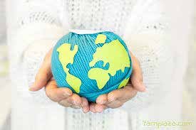 A globe made of yarn held in two hands